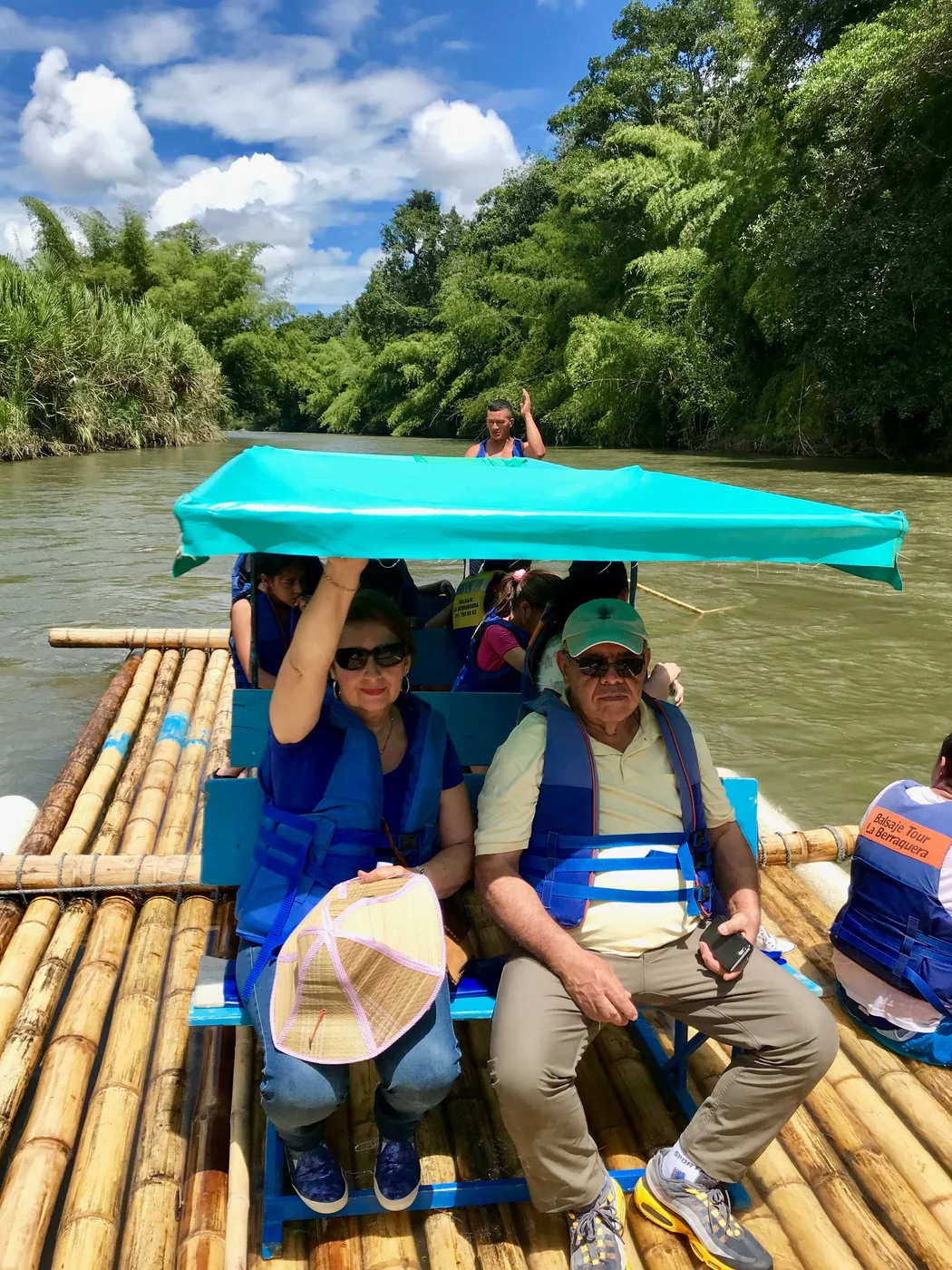 Pareja disfrutando el balsaje bajo la carpa de la balsa de guadua en el Río La Vieja