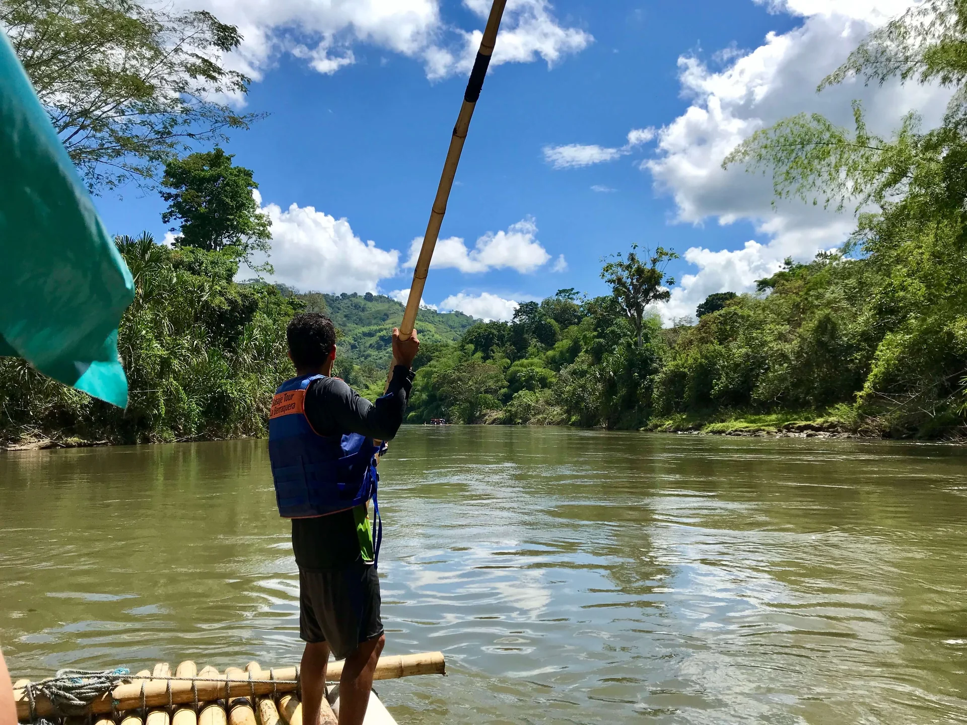 Boga conduciendo la balsa con una vara de guadua