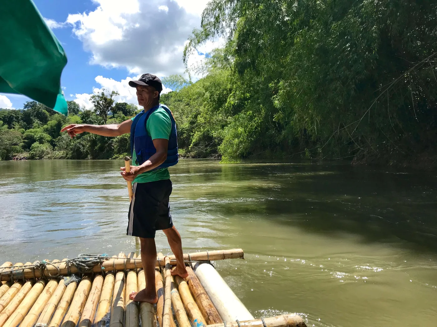 Un boga conduciendo la balsa de guadua con una vara en el Río La Vieja