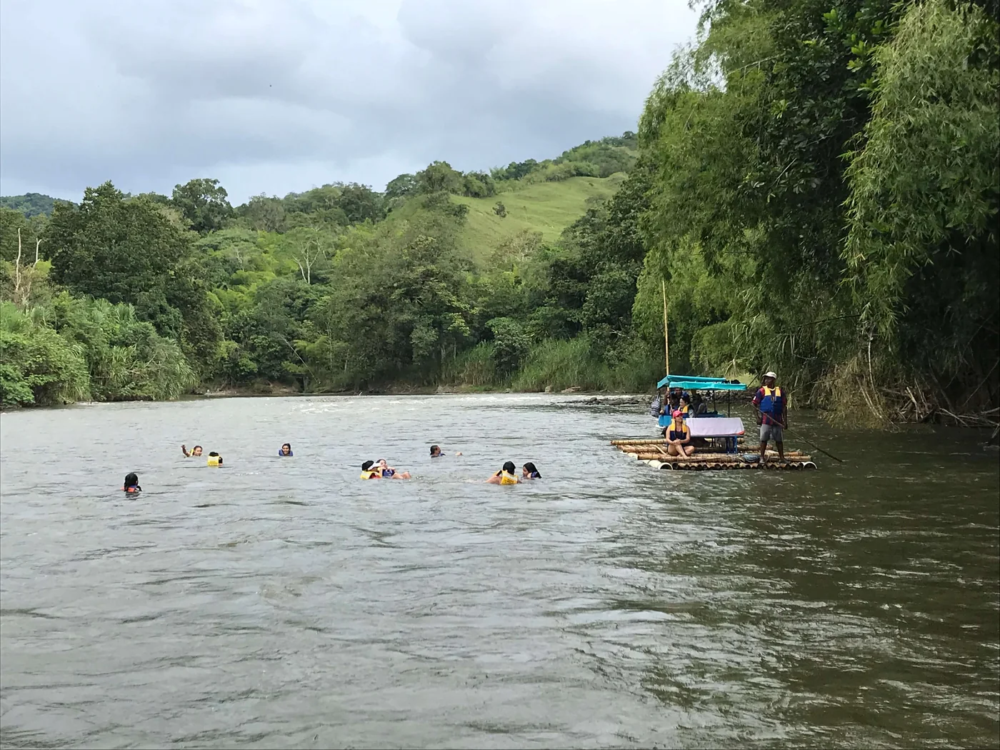 Personas dándose un chapuzón en el Río La Vieja junto a la balsa