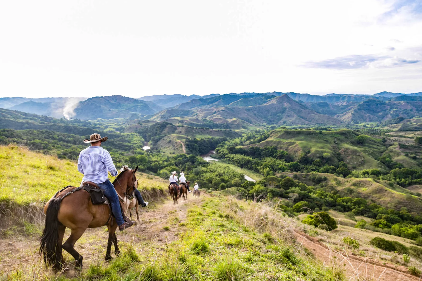 Grupo de jinetes descendiendo por la ladera hacia el cañón de los ríos Espejo y La Vieja