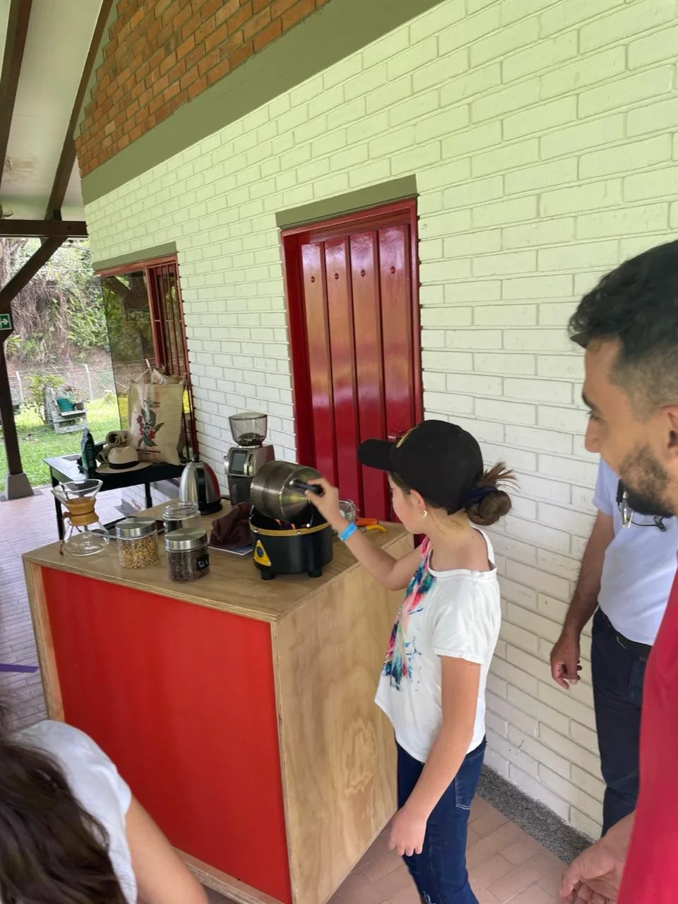 Visitante tostando café en tostadora manual en Finca El Pensamiento