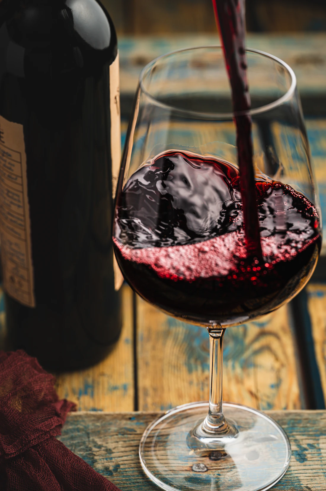 Copa de vino tinto servida junto a la botella